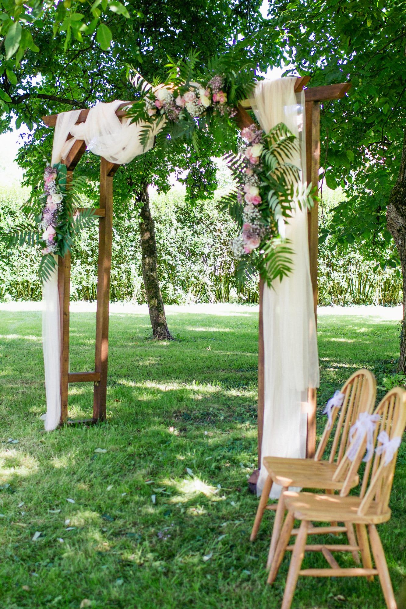 Wooden ceremony arch dressed with flowers and drapes