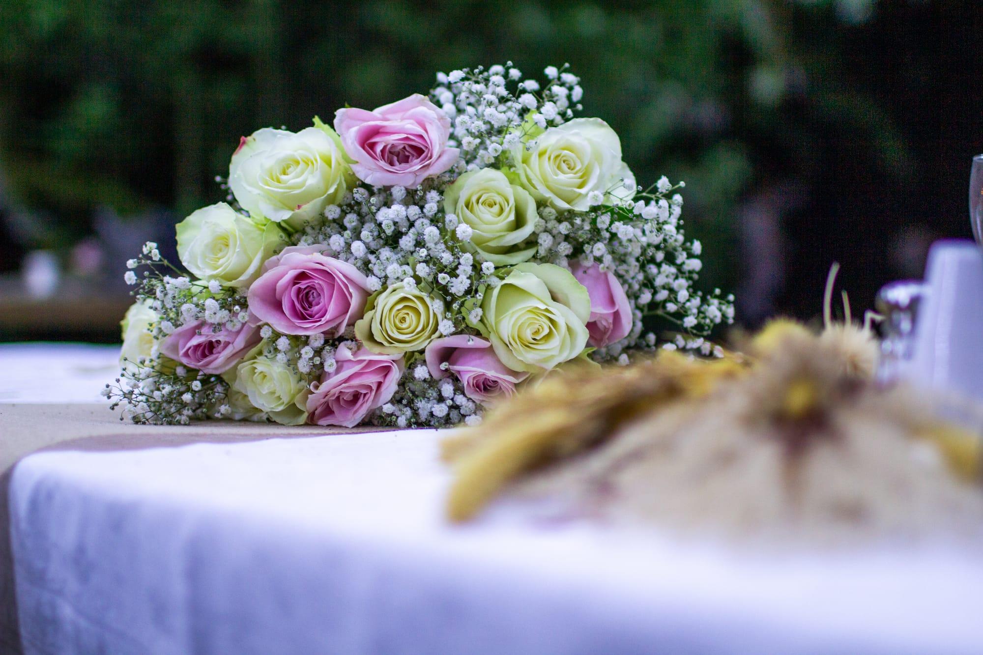 Bouquet de roses pastel et gypsophile posé sur une table