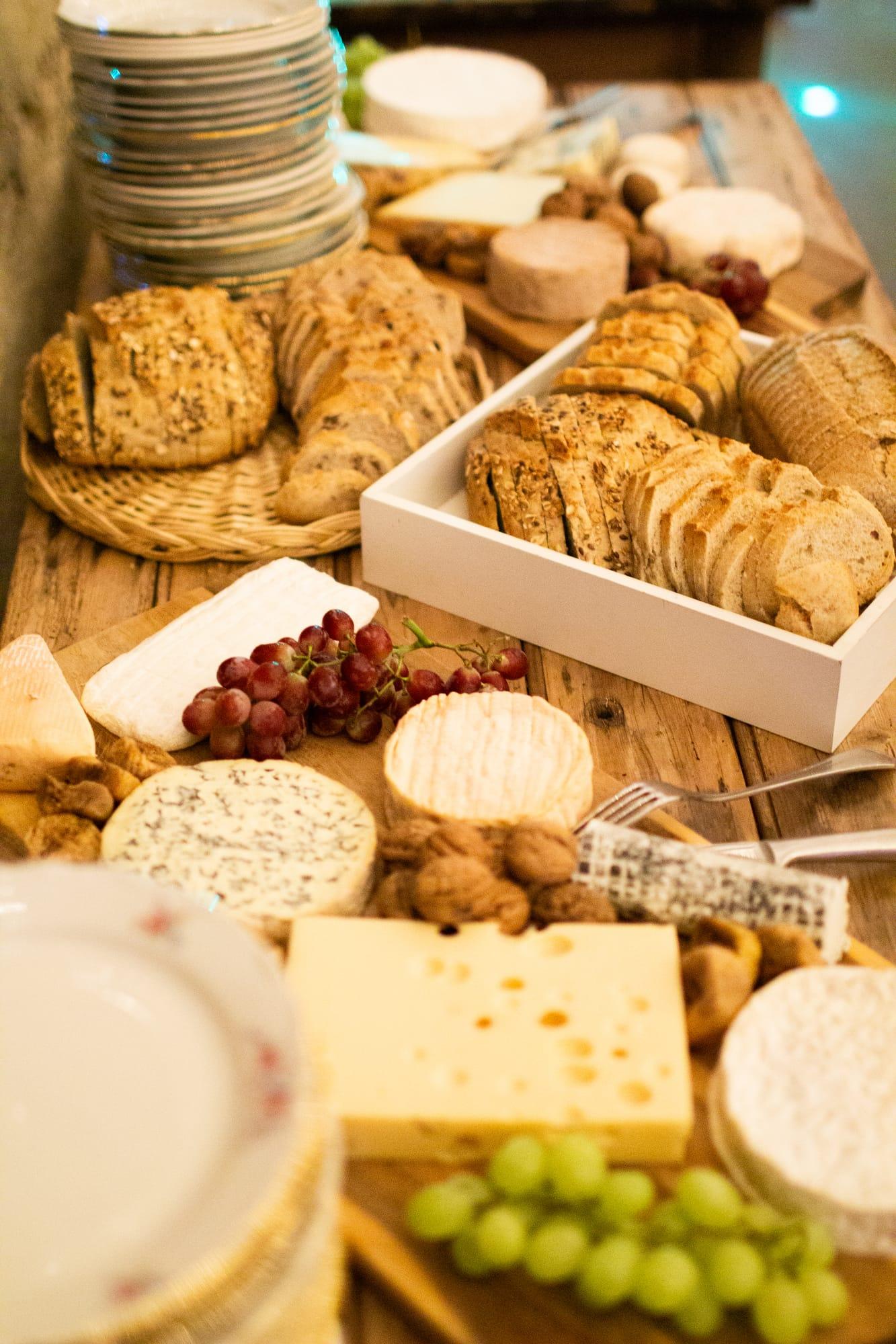 Buffet gourmand de fromages, pains et raisins sur bois brut