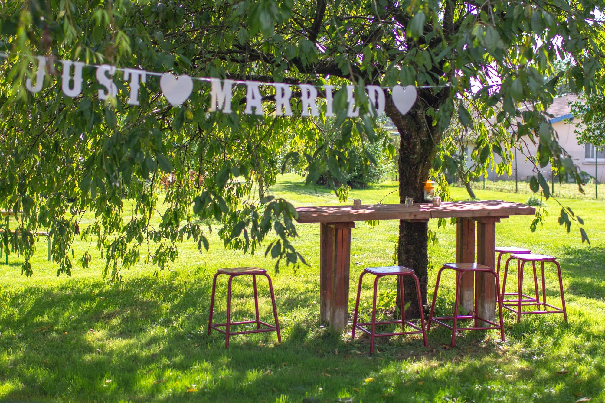 Guirlande « Just Married » suspendue dans les arbres au-dessus des mange-debout