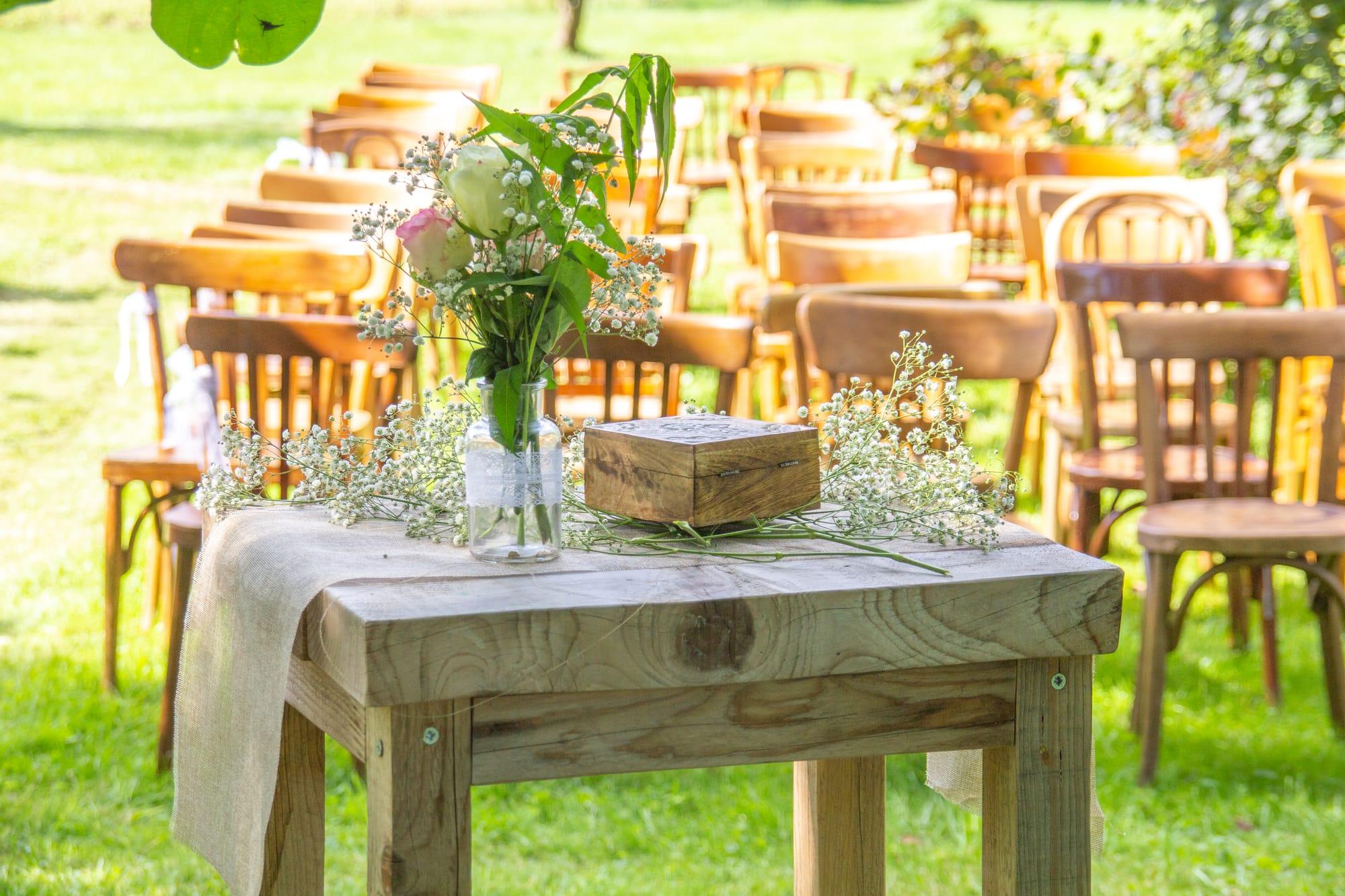 Table en bois brut, chemin de lin et fleurs des champs pour la cérémonie