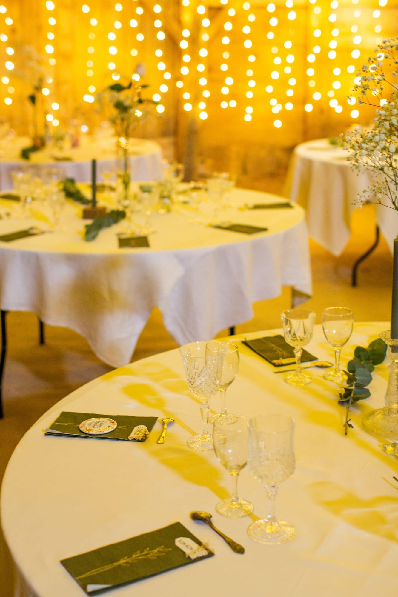 Tables de réception dressées sous un rideau de lumières dorées